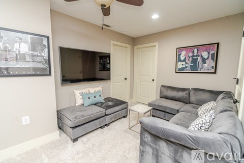 A living room with grey couches and a television.
