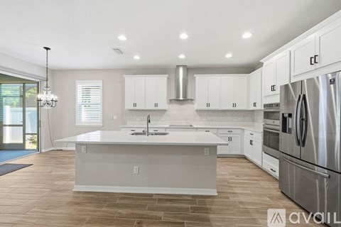 A modern kitchen with white cabinets and a large island.