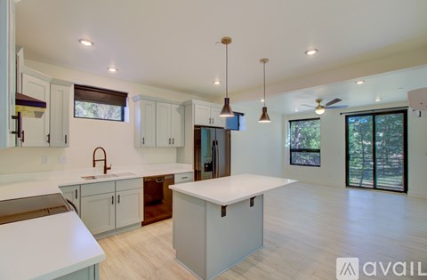 A kitchen with white cabinets and a large island in the middle.