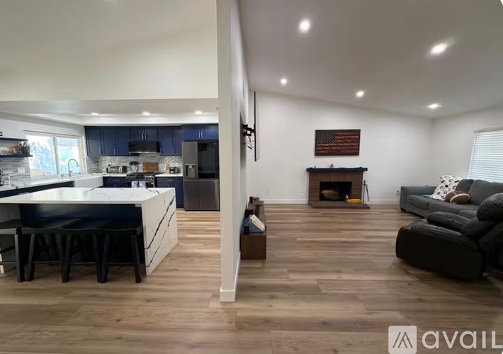 A modern kitchen with a dining area and a living room with a fireplace.