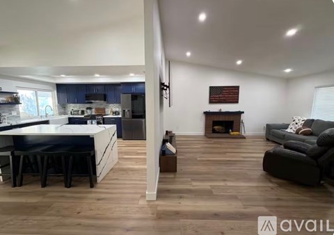 A modern kitchen with a dining area and a living room with a fireplace.