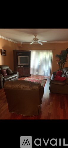 A living room with a brown leather chair and ottoman.