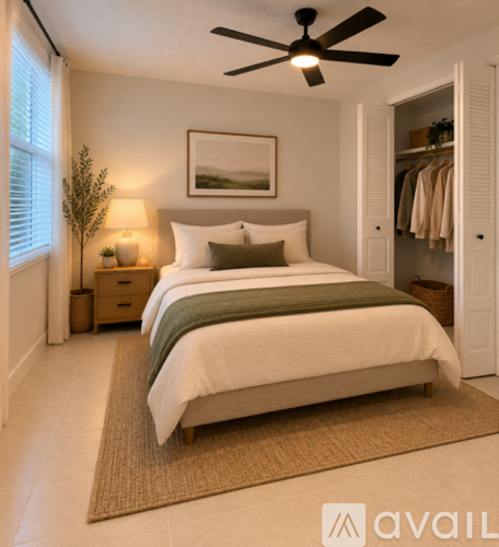 A bedroom with a bed, a ceiling fan, and a wardrobe.