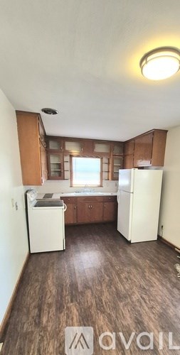 A kitchen with wooden floors and white appliances.