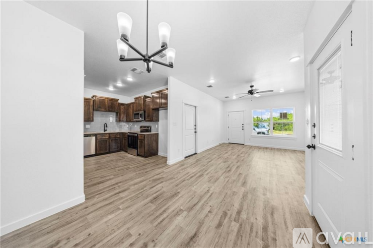 A spacious room with wooden flooring and a ceiling fan.