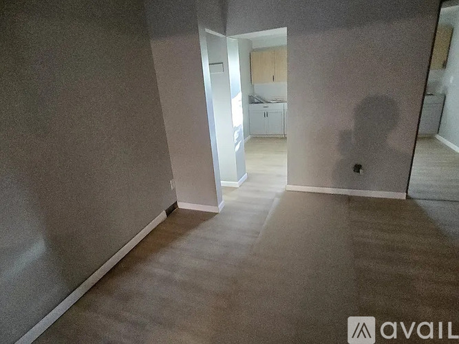 A room with a carpeted floor and a wall on the left side.