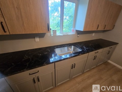 A kitchen with wooden cabinets and a window.