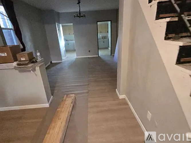 A room with a white wall and a wooden plank on the floor.