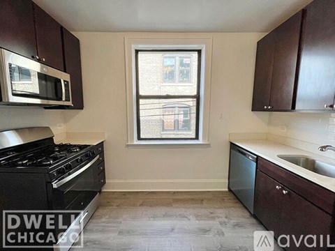 A kitchen with a black stove top oven and a window with a view of a city.