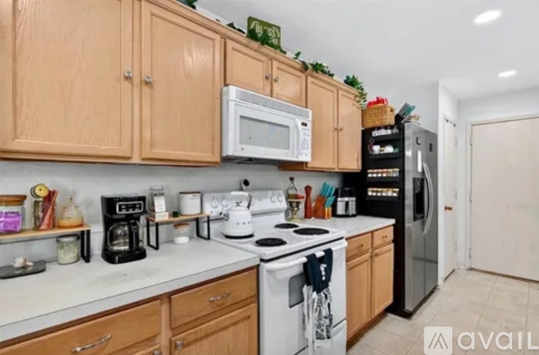 A kitchen with wooden cabinets and a white stove top oven.