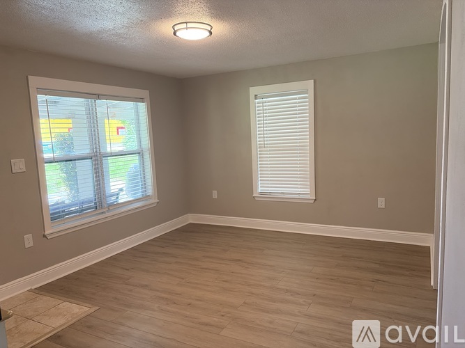 A room with a window and a wooden floor.