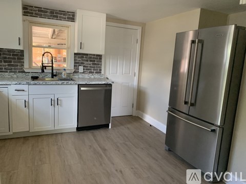 A kitchen with a refrigerator on the right side.