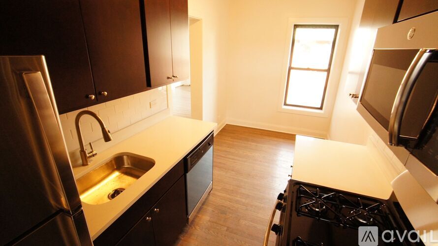 A kitchen with dark wood cabinets and stainless steel appliances.