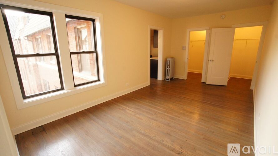 A room with wooden floors and two windows.