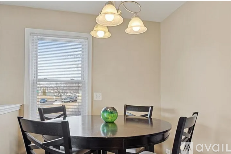 A dining room with a table, chairs, and a window.