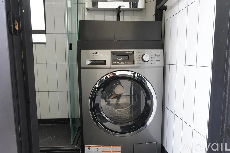 A front view of a silver and black front loading washing machine.