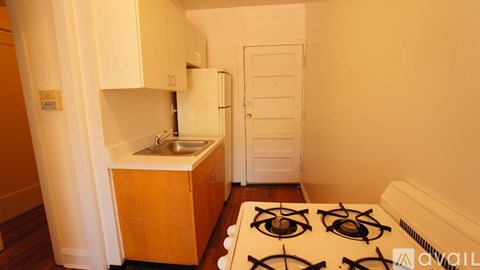 A small kitchen with a stove top and a sink.