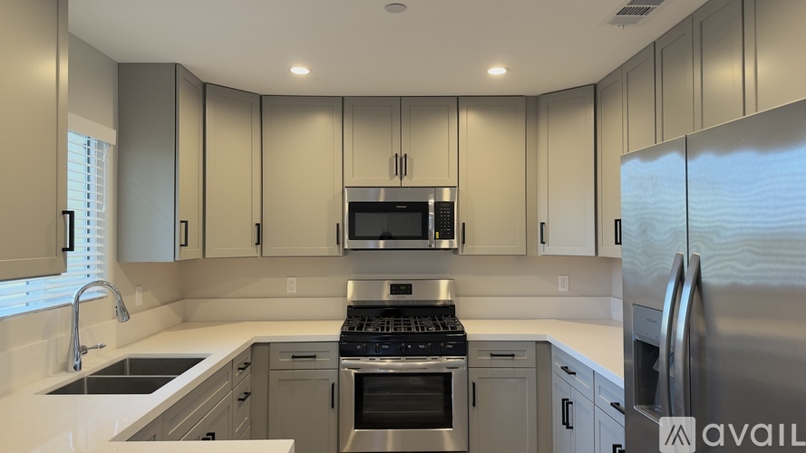 A modern kitchen with stainless steel appliances and white countertops.