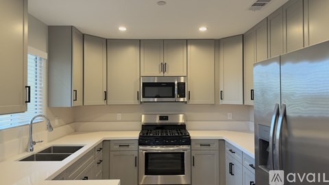 A modern kitchen with stainless steel appliances and white countertops.