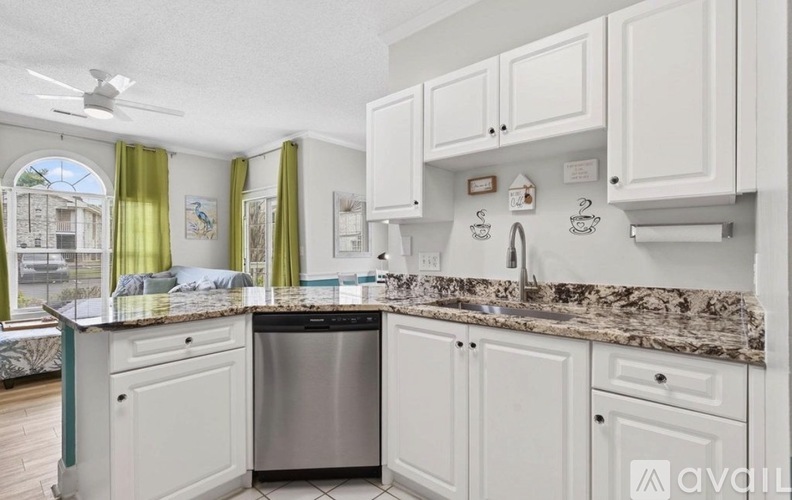 A kitchen with white cabinets and a granite countertop.