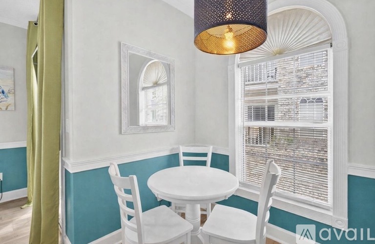 A dining room with a white table and chairs.
