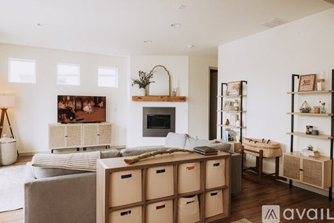 A living room with a grey couch and a wooden cabinet.