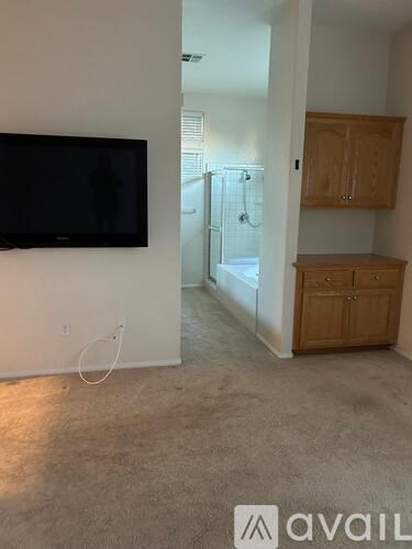 A living room with a television and a cabinet.