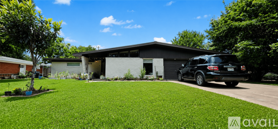 A black car is parked in front of a house.