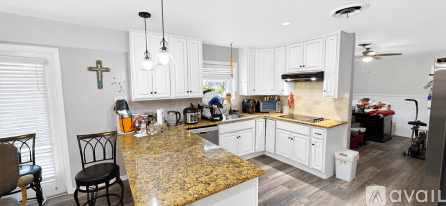 A kitchen with granite countertops and white cabinets.