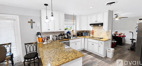 A kitchen with granite countertops and white cabinets.