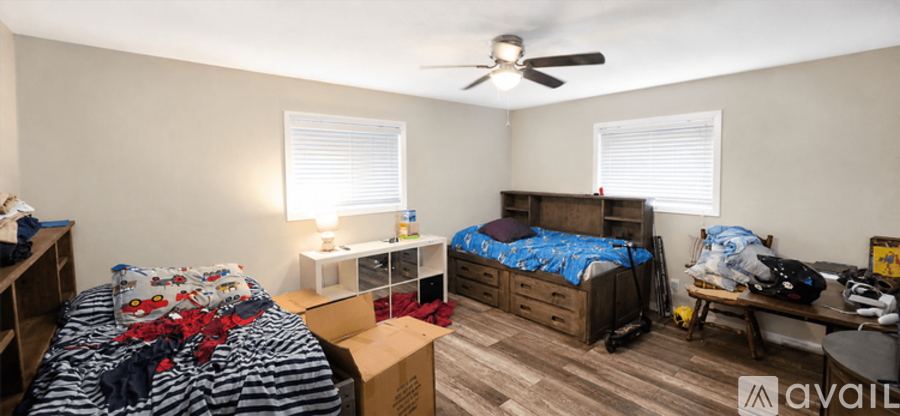 A bedroom with two beds and a ceiling fan.