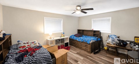 A bedroom with two beds and a ceiling fan.