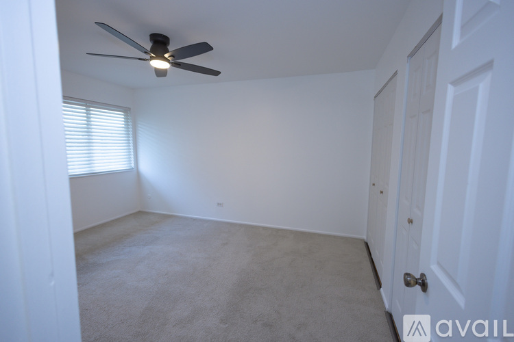 A room with a ceiling fan and a door.