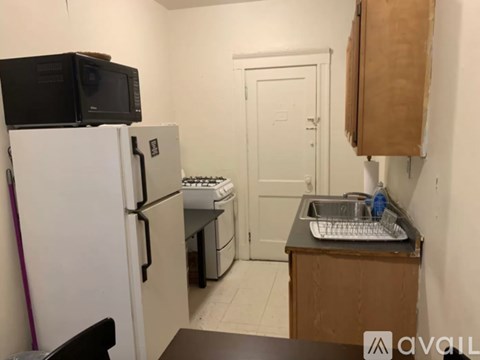 A kitchen with a white fridge, a microwave, a sink and a stove.