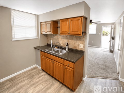 A kitchen with wooden cabinets and a granite countertop.