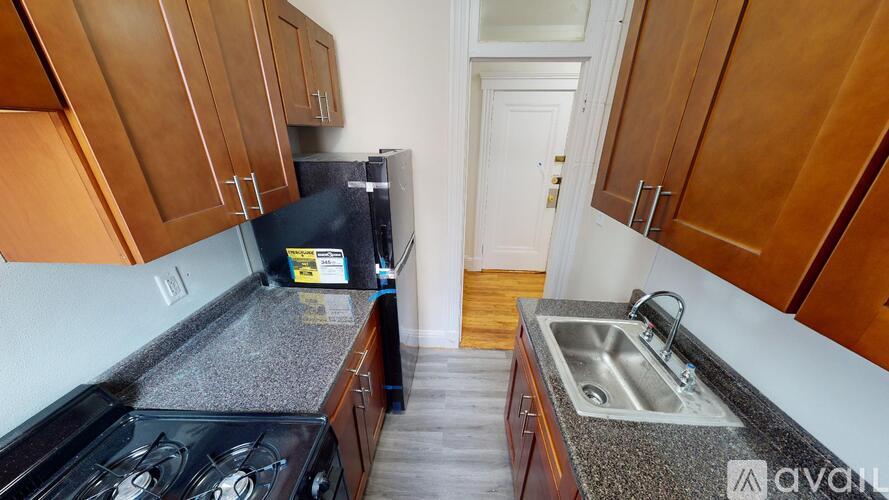 A kitchen with wooden cabinets and a black stove top oven.