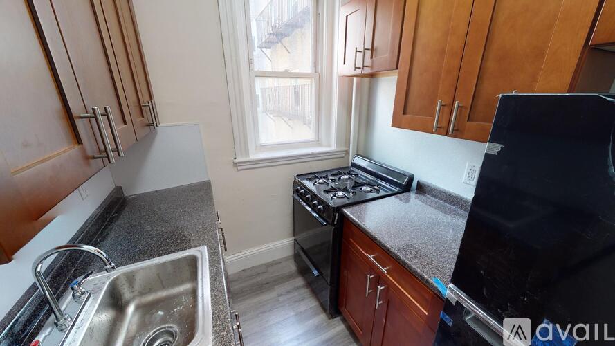 A kitchen with wooden cabinets and a black countertop.