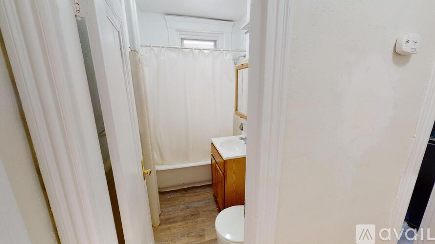A small bathroom with a toilet, sink and shower.