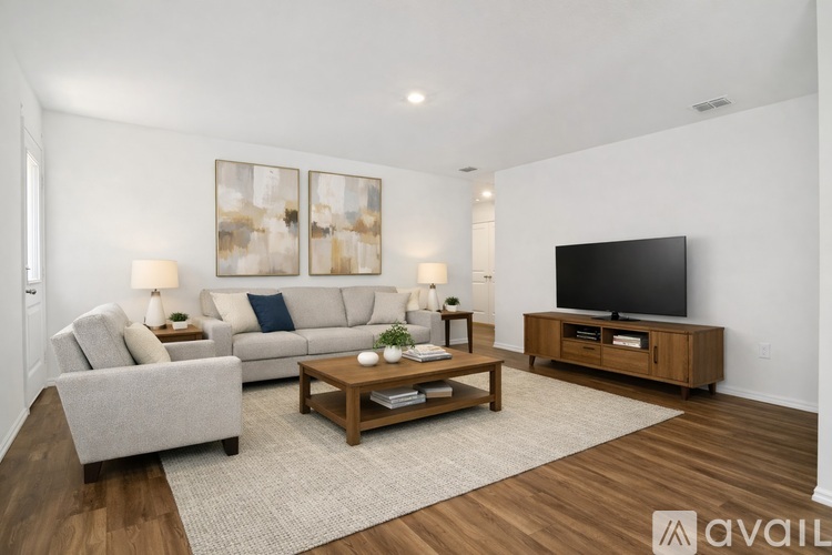 A living room with a grey sofa, a wooden coffee table, and a television.
