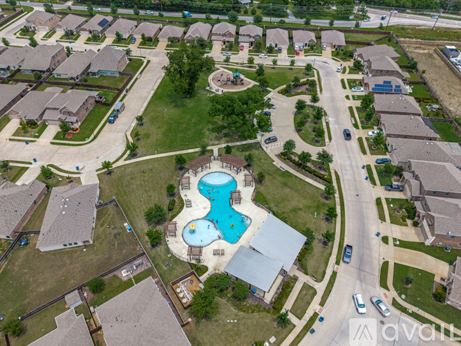 A bird's eye view of a neighborhood with a swimming pool in the center.