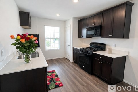 A kitchen with black cabinets and a white countertop.