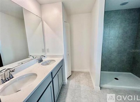 A bathroom with a sink, mirror, and shower.