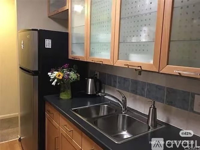 A kitchen with a black fridge and a sink.