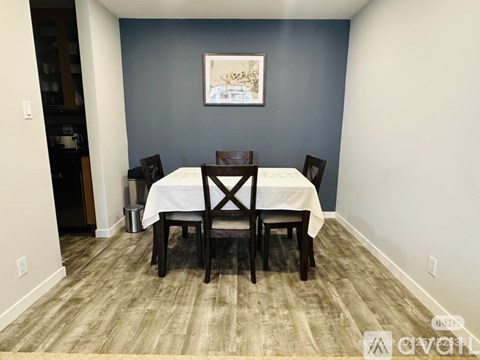 A dining room with a white table and chairs.