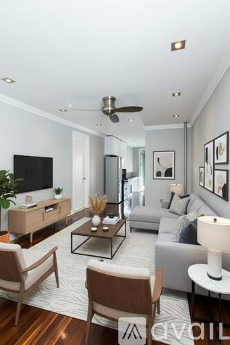 A living room with a grey couch, a wooden coffee table, and a television.