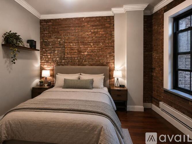 A bedroom with a brick wall and a large bed.