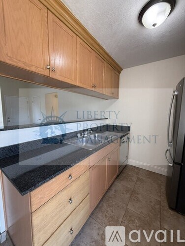 A kitchen with wooden cabinets and a black countertop.