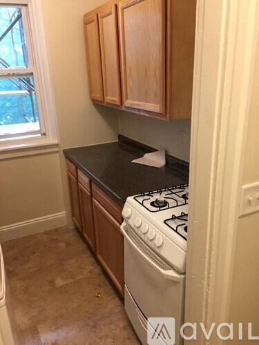 A kitchen with a white stove and wooden cabinets.