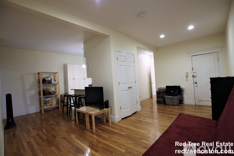 A living room with a wooden floor and white walls.