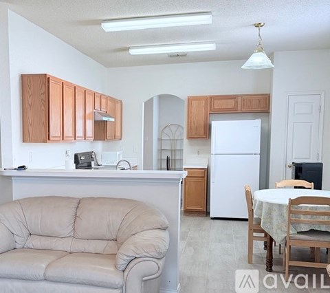 A kitchen with a white refrigerator and wooden cabinets.